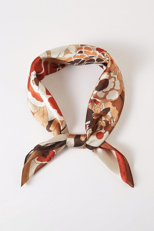 Square scarf with a floral pattern, bright colors, and a contrasting border