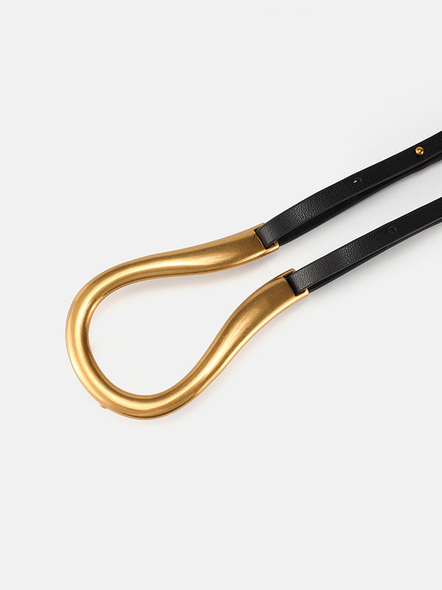 Smalle zwarte riem in minimalistische stijl met asymmetrische gouden gesp