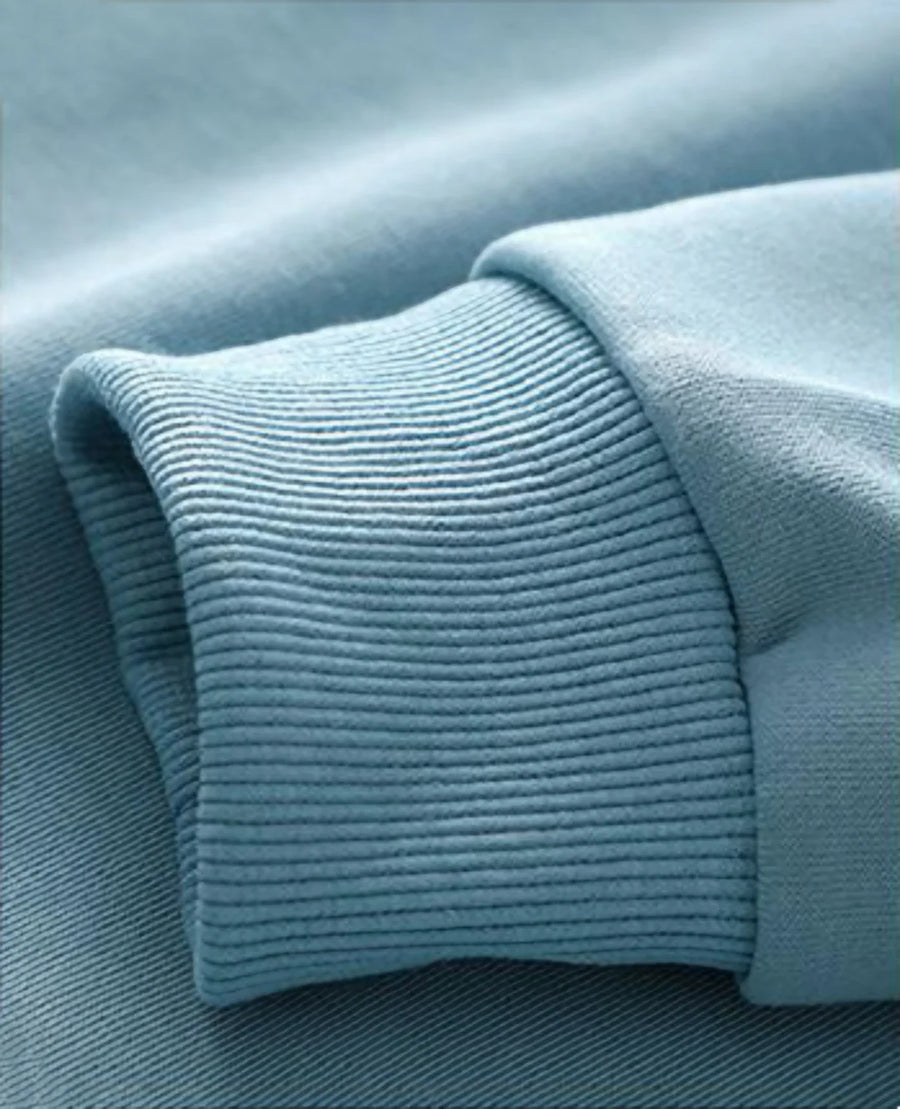 Avslappnad unisex sweatshirt med rund hals, långa ärmar och enfärgad design