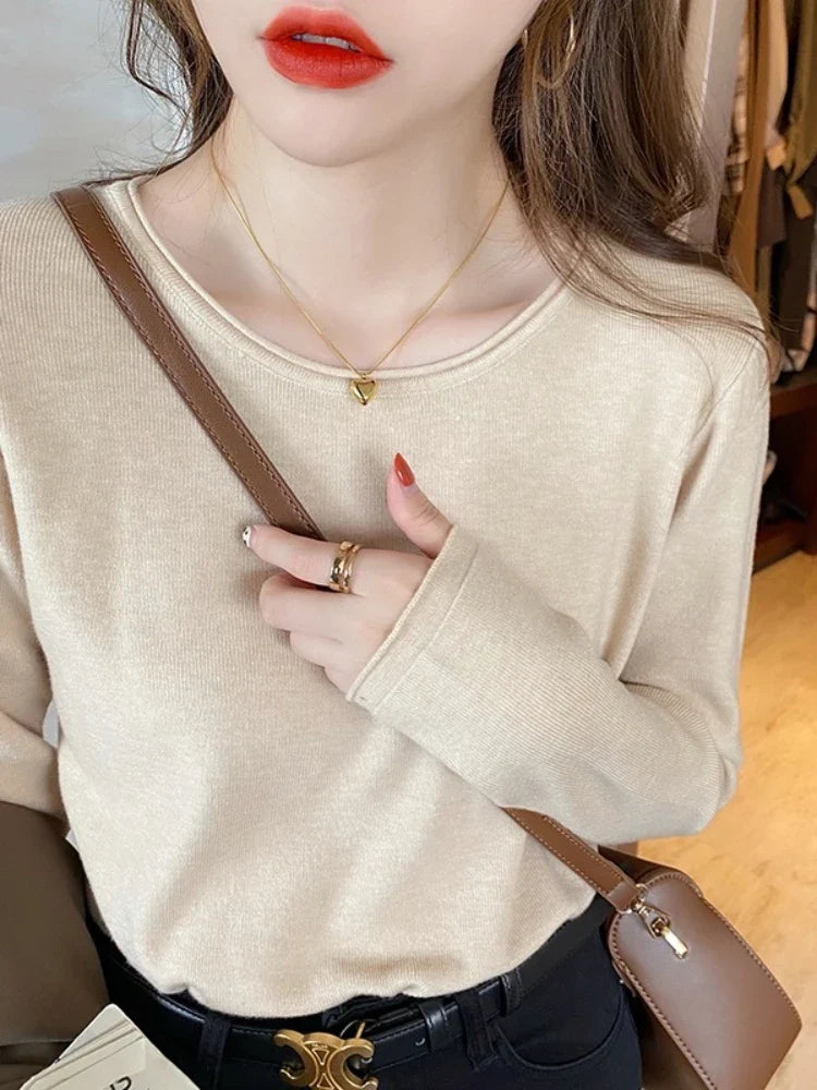 Ensfarvet, tynd damestrik med rund hals og lange, bløde ærmer