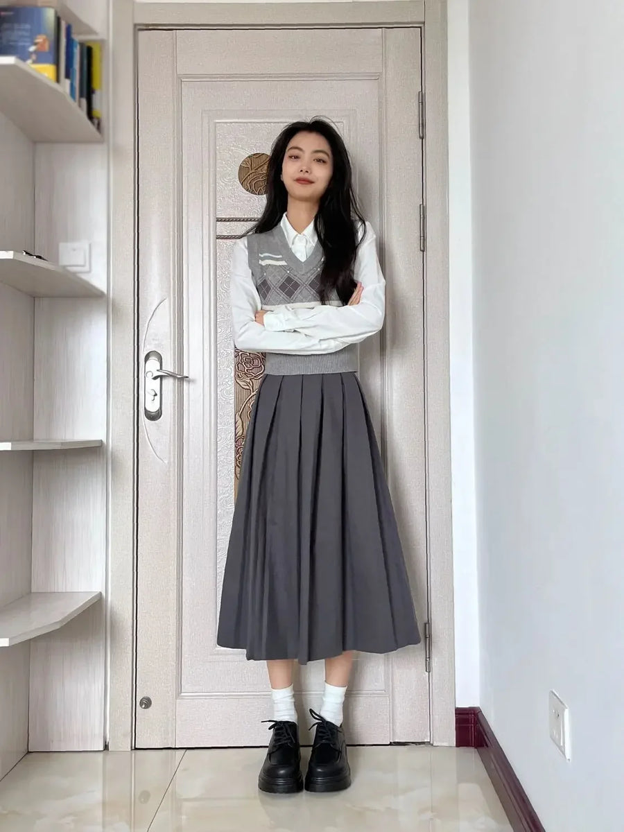 Damski zestaw składający się z szarej plisowanej długiej spódnicy i kraciastej kamizelki bez rękawów w stylu preppy