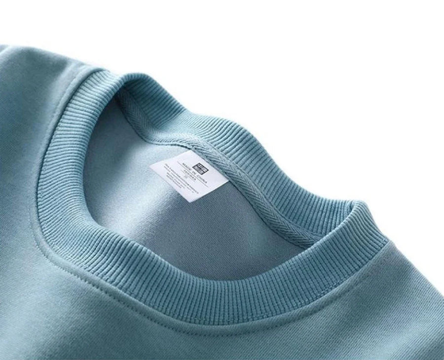 Avslappnad unisex sweatshirt med rund hals, långa ärmar och enfärgad design