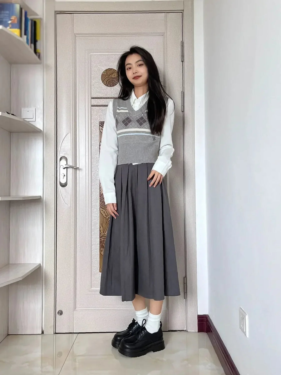 Damski zestaw składający się z szarej plisowanej długiej spódnicy i kraciastej kamizelki bez rękawów w stylu preppy