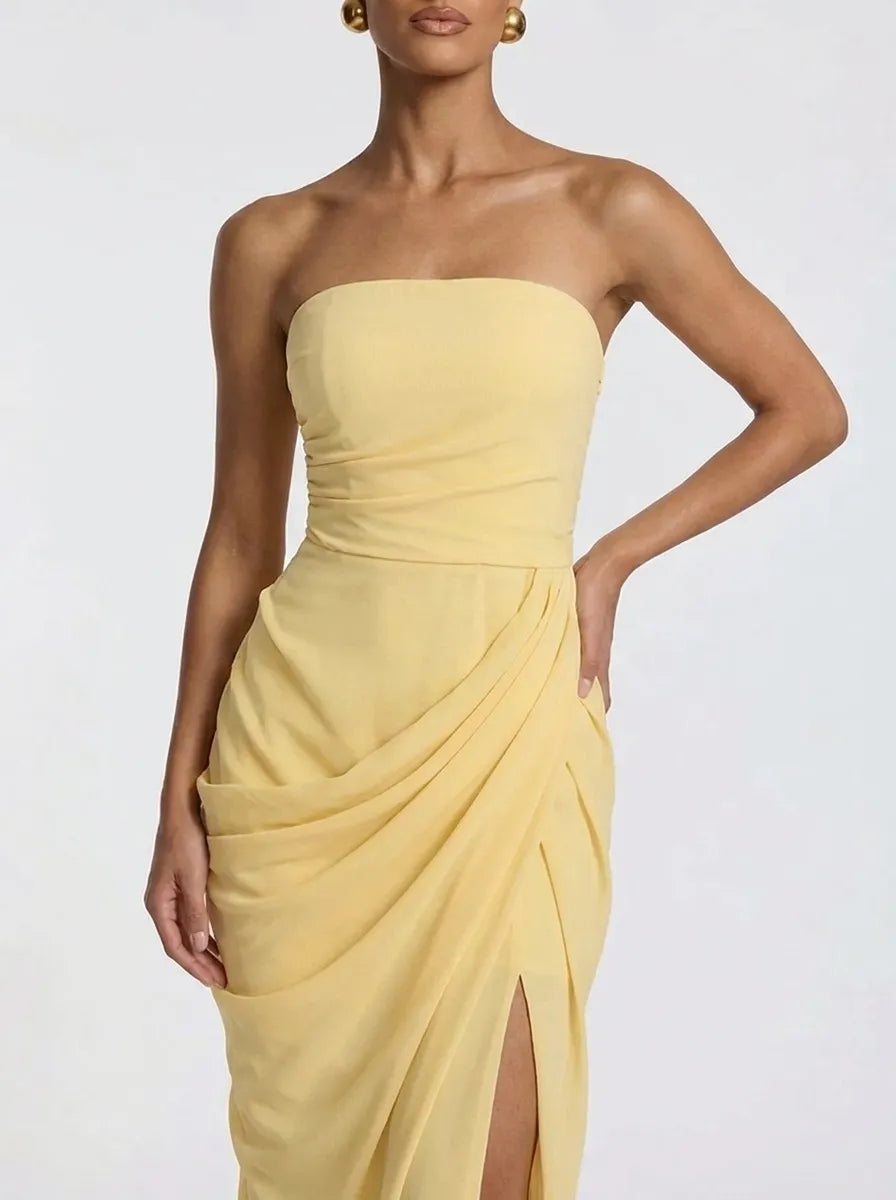Women's pale yellow strapless pleated maxi dress with a slit