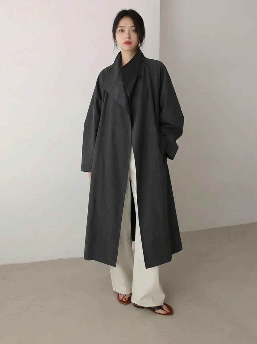 Lange zwarte damestrenchcoat met ceintuur en dubbele rij knopen