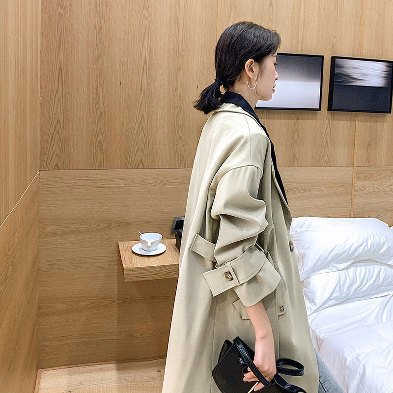 Tweekleurige lange damestrenchcoat in zwart en beige, ruim model