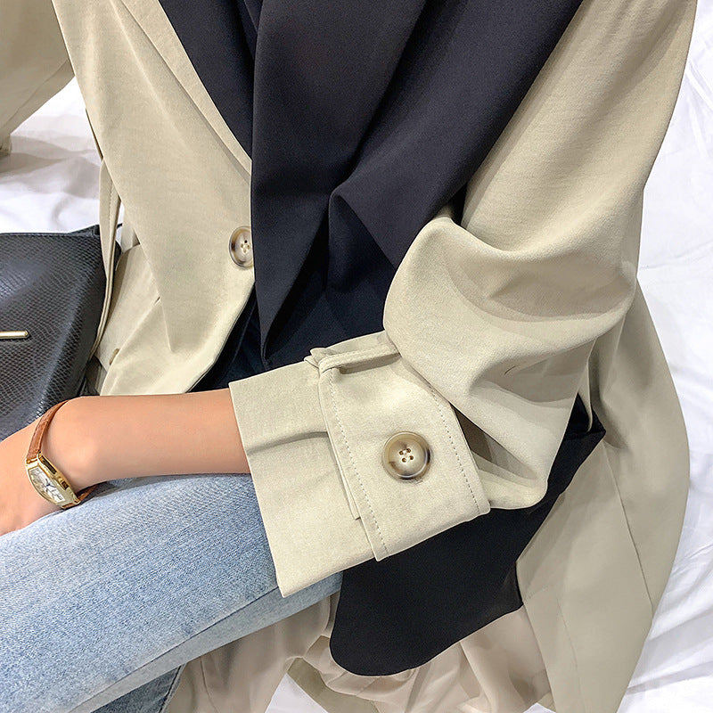 Tweekleurige lange damestrenchcoat in zwart en beige, ruim model