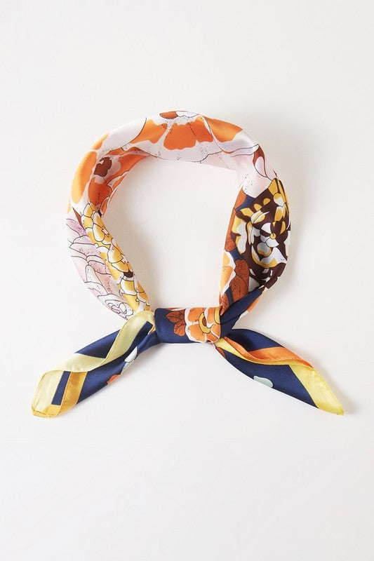 Square scarf with a floral pattern, bright colors, and a contrasting border
