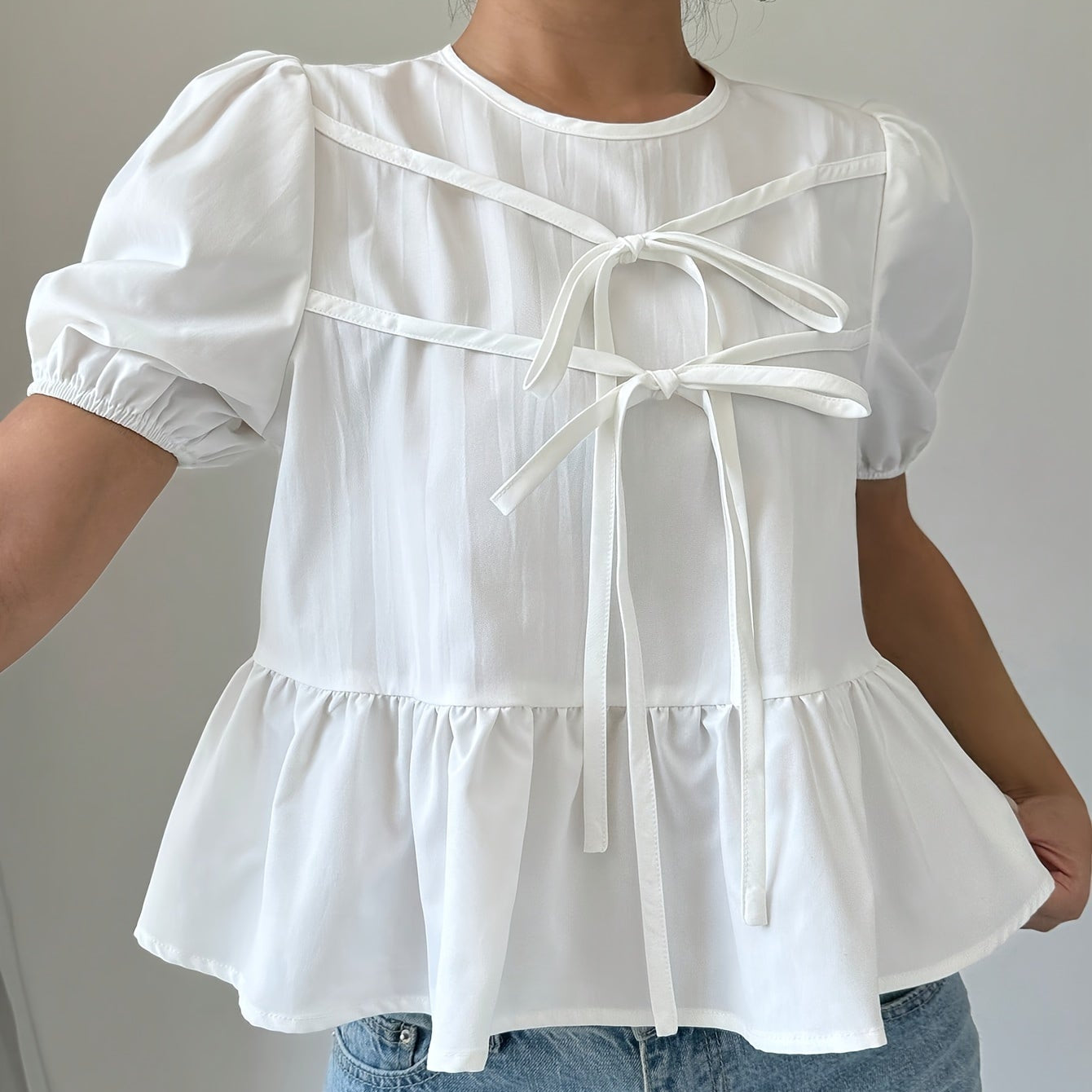 Blouse femme style romantique à manches bouffantes et nœuds décoratifs, coupe peplum tendance pour look casual chic