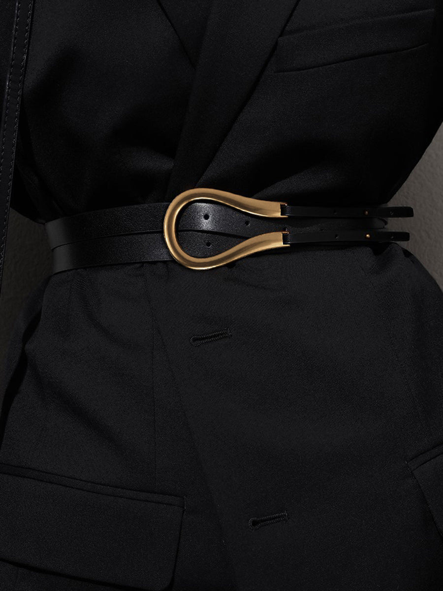 Smalle zwarte riem in minimalistische stijl met asymmetrische gouden gesp