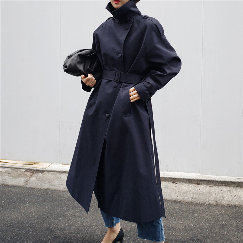 Lang trenchcoat for dame med knappet ståkrage, belte og lys khakifarge