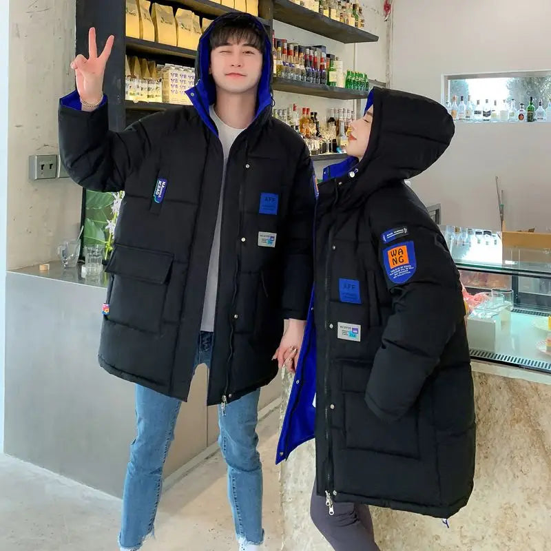 Piumino lungo unisex trapuntato con cappuccio foderato a contrasto e molteplici tasche da uomo e da donna