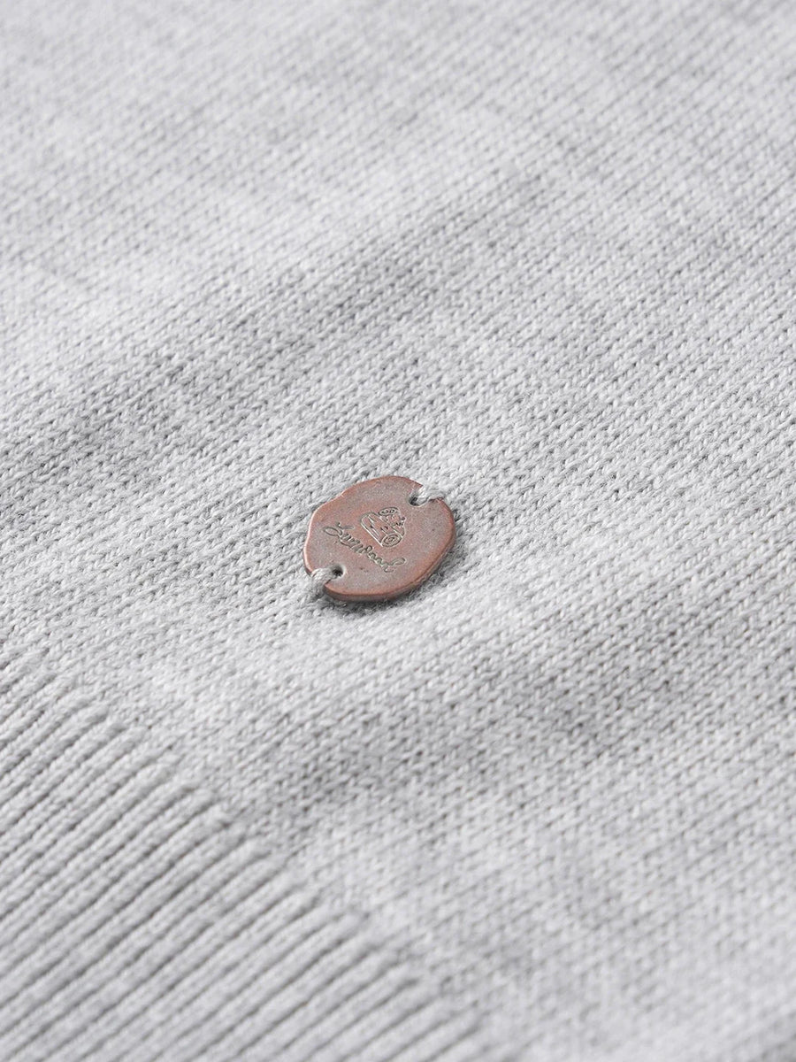 Rundhalsad finstickad herrtröja med liten emblem och långa ärmar