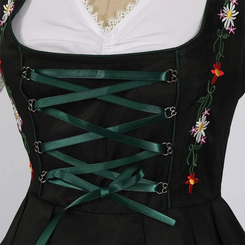 Traditionel grøn og sort dirndl-kjole med blomsterbroderier og hvid bluse