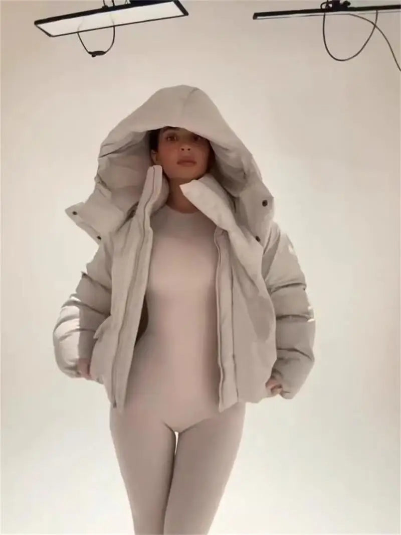 Piumino corto da donna con cappuccio e tasche con patta