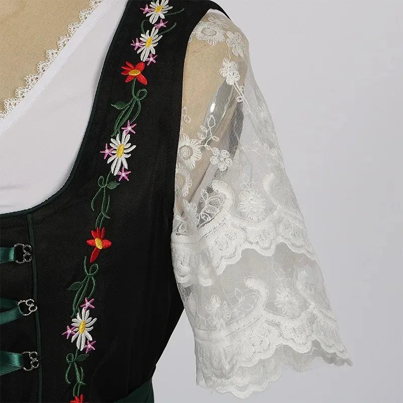 Traditionel grøn og sort dirndl-kjole med blomsterbroderier og hvid bluse