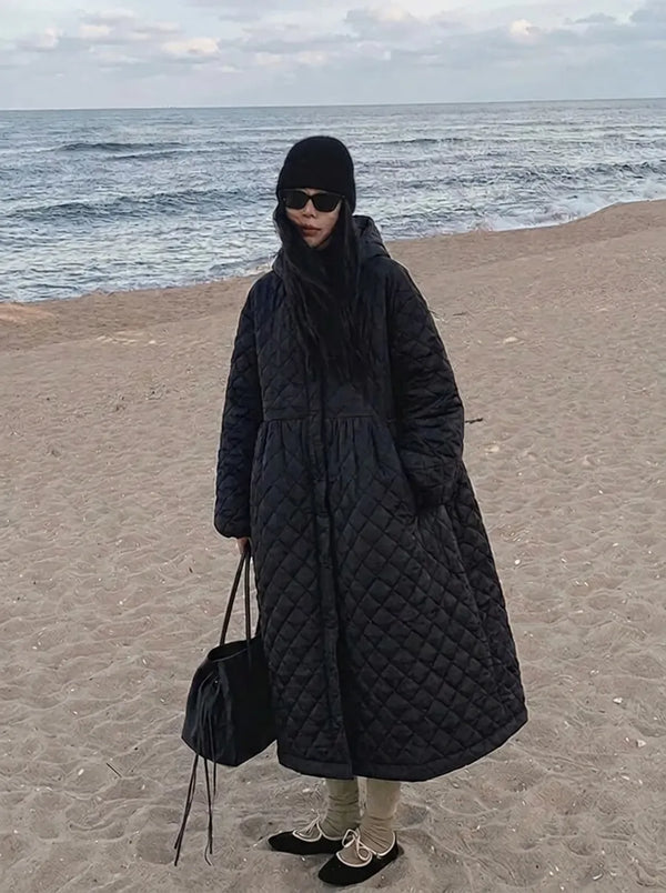 Cappotto lungo trapuntato nero da donna con cappuccio e taglio svasato