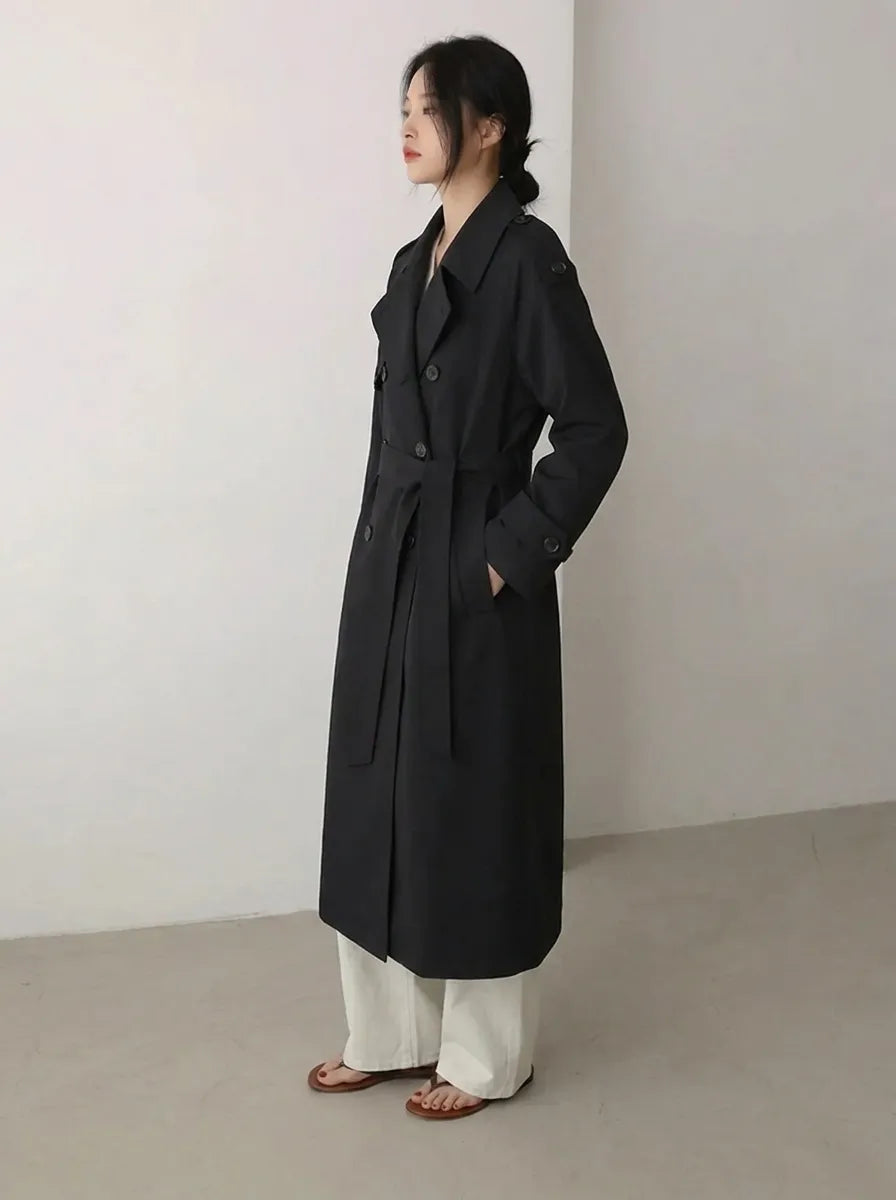 Lange zwarte damestrenchcoat met ceintuur en dubbele rij knopen