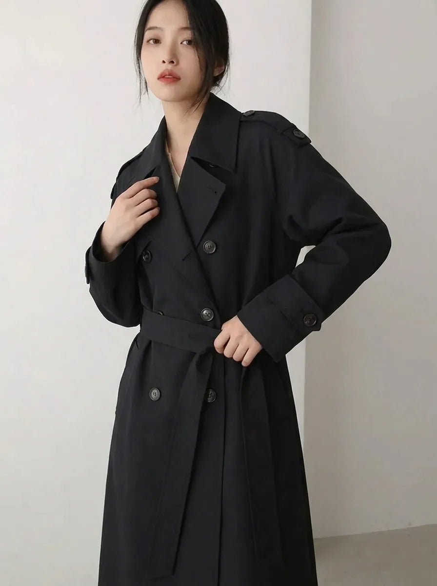 Lange zwarte damestrenchcoat met ceintuur en dubbele rij knopen