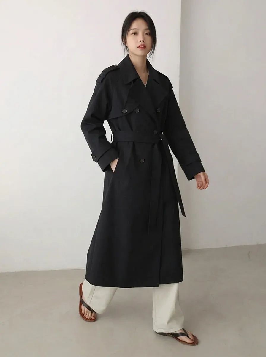 Lange zwarte damestrenchcoat met ceintuur en dubbele rij knopen