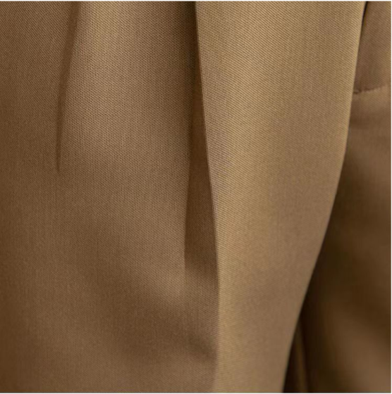 Beige herrbyxor med plissering, avsmalnande passform och ankellång längd